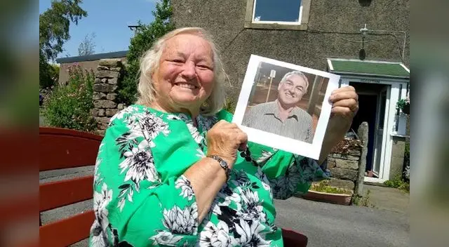 Issy Carr junto a una foto de su hijo Keith luego de 66 años de intensa búsqueda. FOTO: SWNS