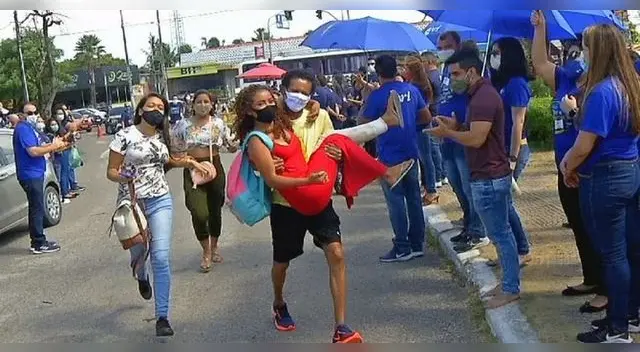 Profesor carga a estudiante lastimada para que resuelva su examen de admisión de la universidad.