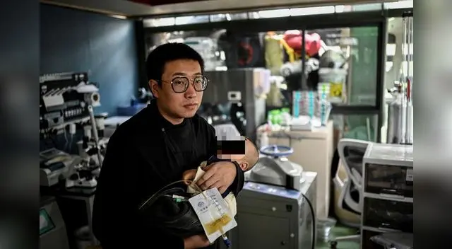 La foto tomada el 21 de octubre de 2021 muestra a Xu Wei sosteniendo a su hijo Xu Haoyang, diagnosticado con síndrome de Menkes. Foto: AFP