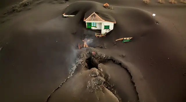 El gran impacto del volcán. En la foto se aprecia la boca por la que salió la lava al pie de una casa que milagrosamente ha sobrevivido.