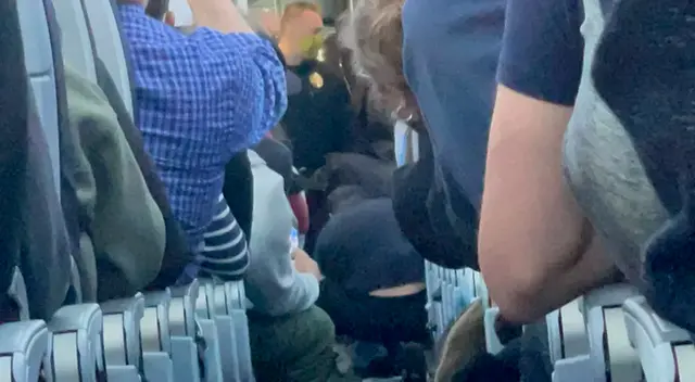 Los pasajeros registraron el momento en que lograron reducir al hombre. Los pasajeros registraron el momento en que lograron reducir al hombre.