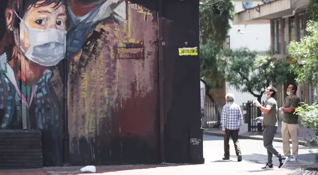 Mural muestra a una escolar con mascarilla en Bogotá, Colombia.