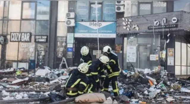 Bomberos intentan apagar un fuego de un edificio civil bombardeado en una zona residencial en Kiev.