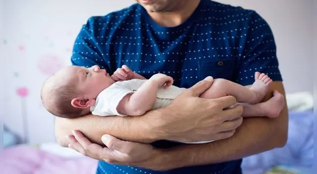 Bebé en brazos de su progenitor. Bebé en brazos de su progenitor.