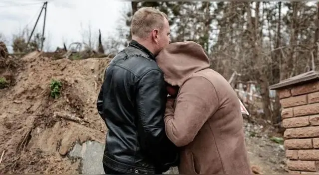 Liudmila es contenida por miembros de la policía durante la exhumación del cuerpo de su hijo.