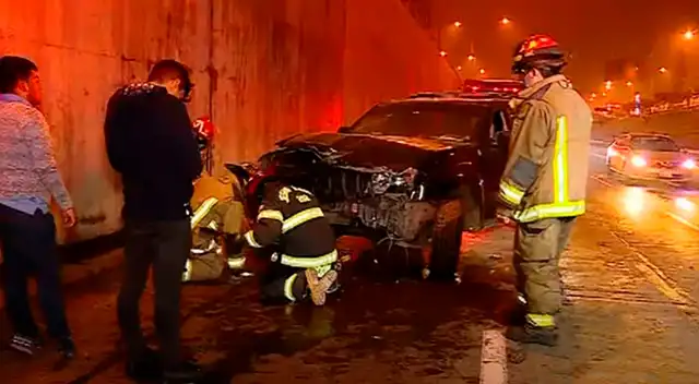 Vehículo accidentado siendo atendido por personal de los bomberos