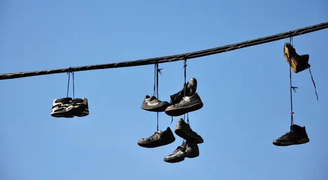 Zapatillas colgadas a lo largo de cables de luz unidas a postes