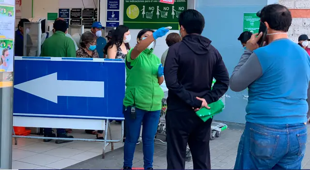 Trabajadora de Tottus tomando temperatura a los clientes Trabajadora de Tottus tomando temperatura a los clientes