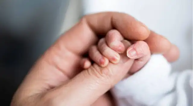 Mano de un recién nacido junto a la de su madre