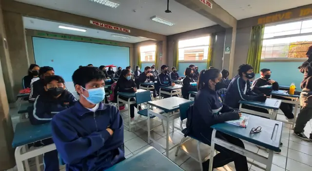 Escolares en clase con sus uniformes representativos de institución