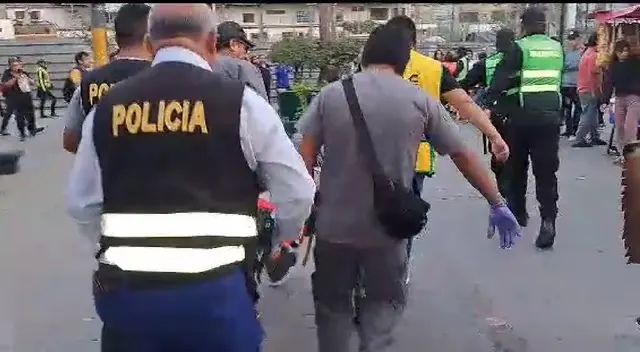 Cambista siendo trasladado por policías. Cambista siendo trasladado por policías.