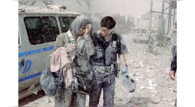 El policía Mike Brennan ayuda a una mujer angustiada tras el atentado terrorista a las Torres Gemelas. El policía Mike Brennan ayuda a una mujer angustiada tras el atentado terrorista a las Torres Gemelas.