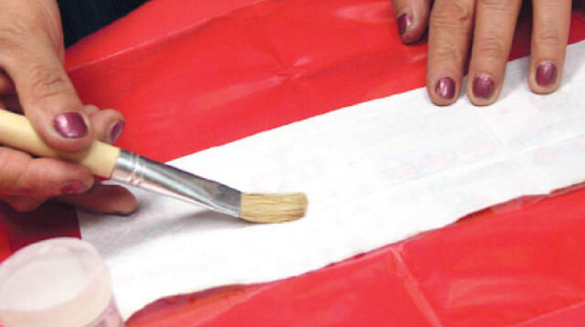 PASO 1. Coloca la servilleta sobre un plástico y aplica servitel por el revés con un pincel. Humedece todo.
