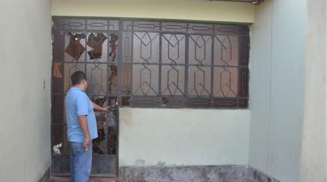 La puerta rota de una casa contigua por donde entraron los policías.