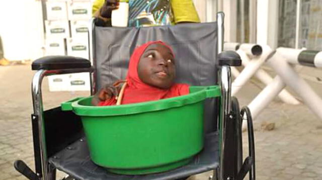 Rahama Haruna y su hermano, con la silla de ruedas que recibieron de regalo.