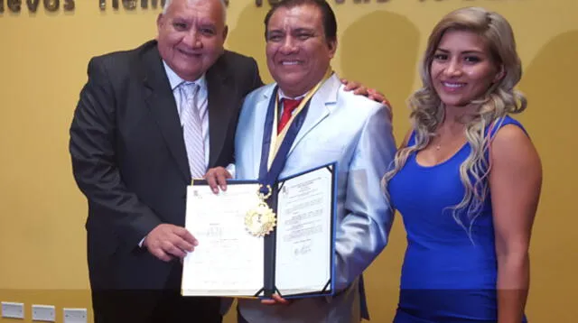 Cómico muestra orgulloso su premio junto a sus amigos y familiares.