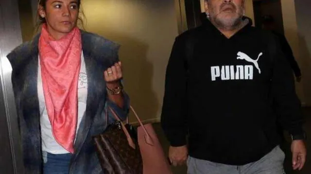 Maradona retirándose del aeropuerto con su novia.