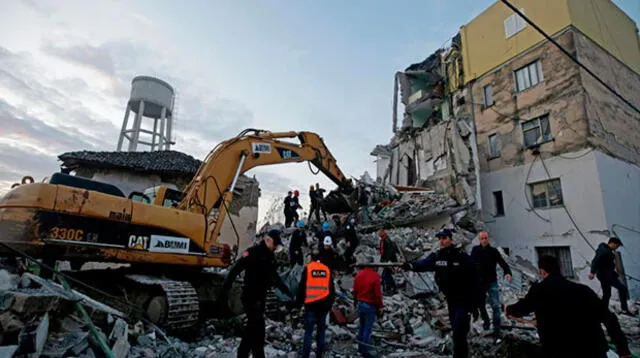 Personas de emergencias trabajan entre las ruinas de un edificio de viviendas en Thumane