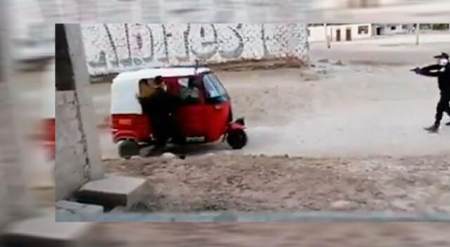 Policía apuntando con su arma a mototaxista.