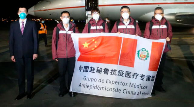 Médicos sostienen bandera que muestra una alianza entre Perú y China.