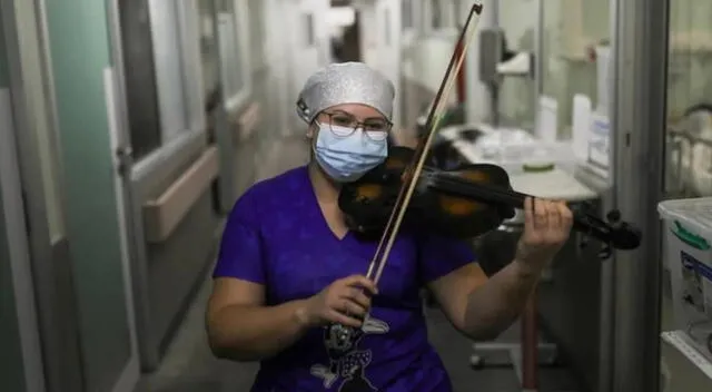 Damaris Silva, de 26 años, toma su violín y toca melodías en la sala de cuidados intensivos.