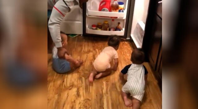 El intento fallido de un padre por cerrar su refrigeradora mientras sus trillizos juegan