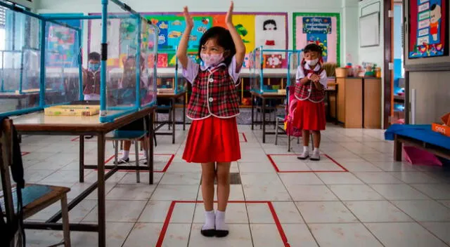Los alumnos se paran en casillas socialmente distanciadas que están marcadas en un aula de la escuela Wat Khlong Toey en Bangkok, Tailandia, el 10 de agosto de 2020.