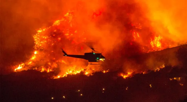 Un helicóptero se prepara para dejar caer agua en un incendio forestal en Yucaipa, California, este sábado.