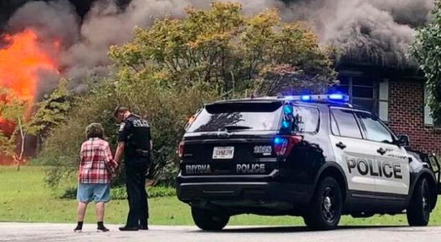 El momento preciso en que la mujer y el policía estadounidense oran en la escena del incendio.