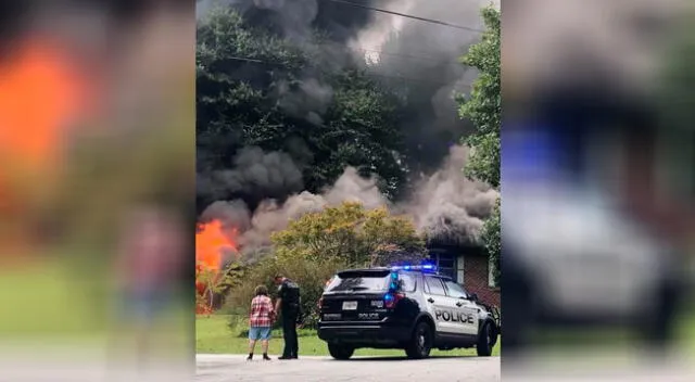 El momento preciso en que la mujer y el policía estadounidense oran en la escena del incendio.