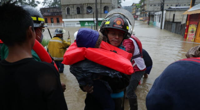 Bomberos ayudan a evacuar a familias de sus viviendas en Guatemala.