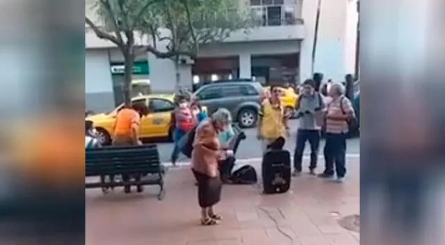 Anciana escucha música y baila en la calle