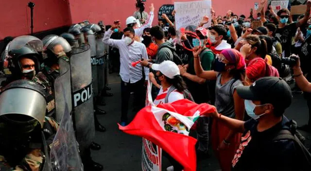 Manifestantes huyen de los gases lacrimógenos durante una protesta contra el gobierno de Manuel Merino.