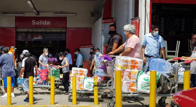 Largas colas para comprar en supermercados.