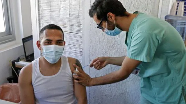 Un extranjero que vive en Israel recibe una dosis de la vacuna contra el coronavirus COVID-19 en el Centro Médico Tel Aviv Sourasky. (Foto de JACK GUEZ / AFP).