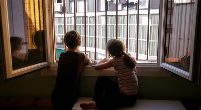 Niños miran por la ventana de su dormitorio durante el confinamiento | Foto: El País/difusión
