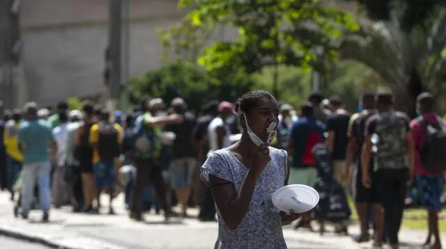 Personas sin hogar reciben almuerzo en el centro de Sao Paulo, Brasil, el 23 de marzo de 2021, en medio de la pandemia de coronavirus.