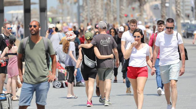 Las personas caminan sin mascarillas cerca de la playa en Tel Aviv. Israel puso fin al uso obligatorio de mascarillas al aire libre tras una exitosa campaña de vacunación contra el coronavirus.