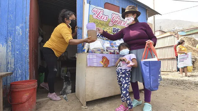 Madre de la olla común entrega ración de alimento a pobladora de San Antonio.
