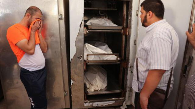 El hermano de Eyad Saleha llora frente a los cadáveres de sus parientes que murieron en un bombardeo de Israel contra su casa en Gaza.