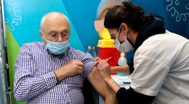 Enfermera administra la cuarta dosis a un adulto mayor en un centro de vacunación de Jerusalén.