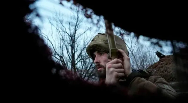 Un miembro del servicio ucraniano escucha disparos de artillería en una trinchera en una posición en la línea de separación en la frontera.
