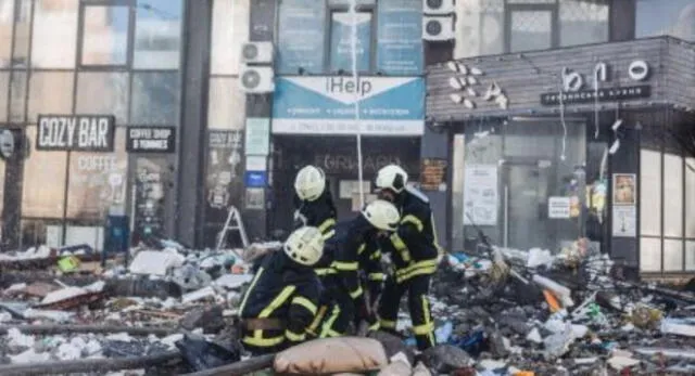 Bomberos intentan apagar un fuego de un edificio civil bombardeado en una zona residencial en Kiev.