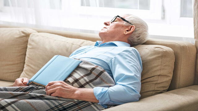 Persona de la tercera edad durmiendo en el sofá.