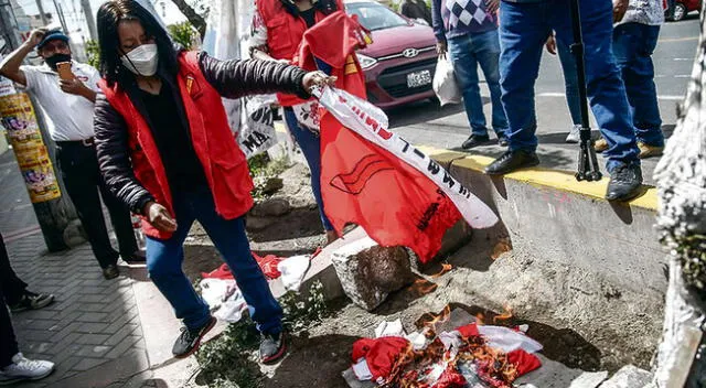 Militantes de Perú Libre queman sus bandera en los exteriores del partido.