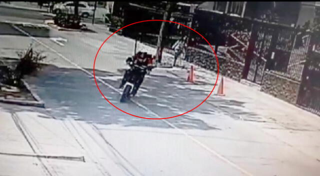 Delincuente en moto robando celular a joven que dejó detrás