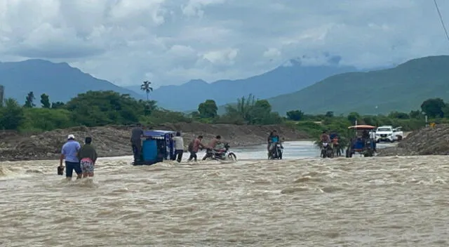 Transportistas arriesgan sus vidas al cruzar sobre crecida de río.