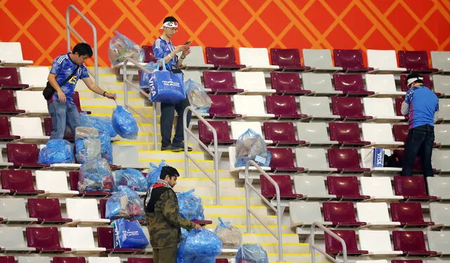 Japoneses recogiendo la basura que dejaron los hinchas.   