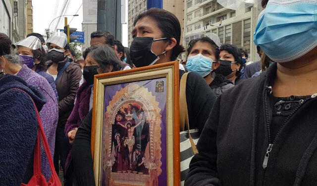  Una señora con la imagen del Señor de los Milagros en los exteriores de la iglesia Las Nazarenas. Foto: Giuliana Castillo/URPI-LR