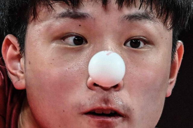  El japonés Tomokazu Harimoto sirve al alemán Dimitrij Ovtcharov durante la semifinal de tenis de mesa de su equipo masculino en el Gimnasio Metropolitano de Tokio el 4 de agosto de 2021.&nbsp;(ADEK BERRY / AFP via Getty Images)   